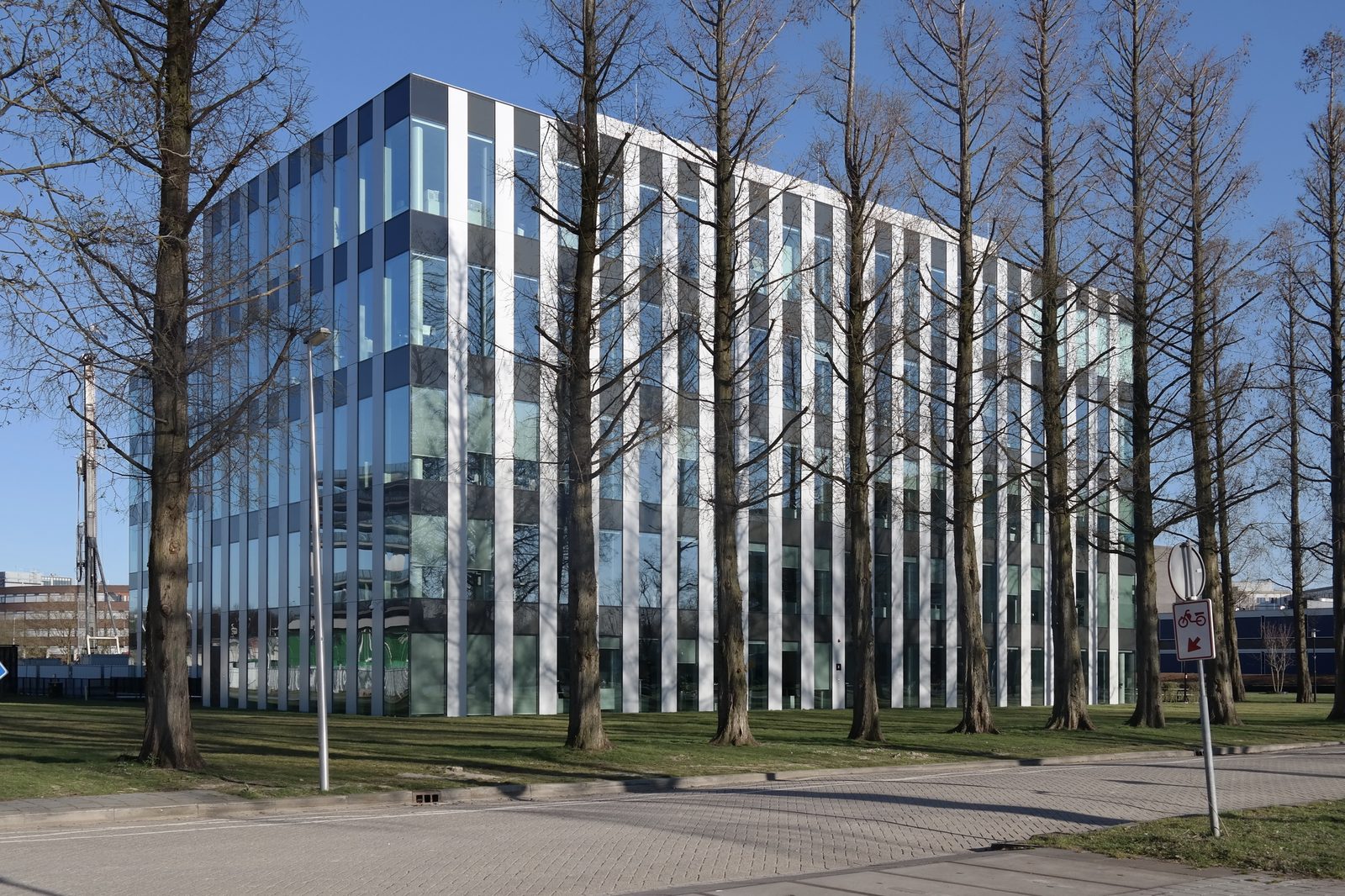 Genmabs kontorbygning på Utrecht Science Park i Holland, med glas- og aluminiumsfacade omgivet af træer